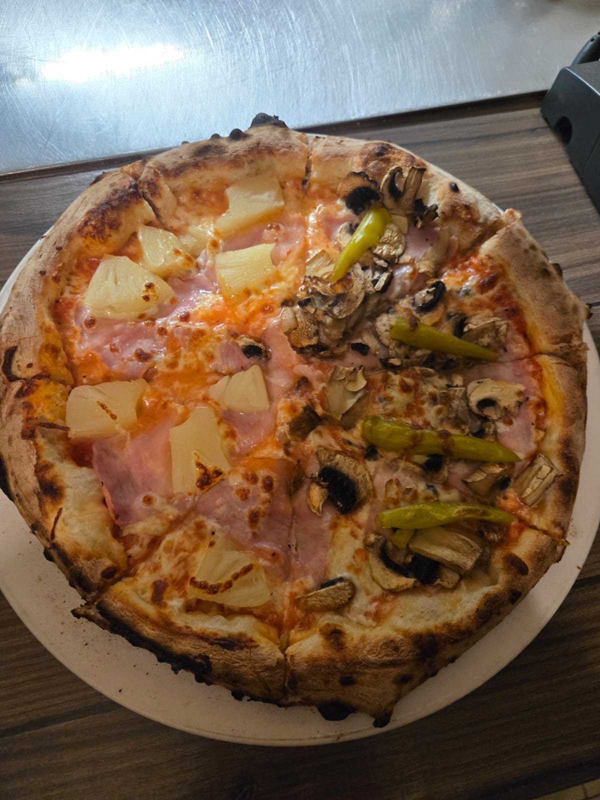 Pizza mit Schinken, Ananas, Pilzen und Peperoni aus dem Dolce far niente